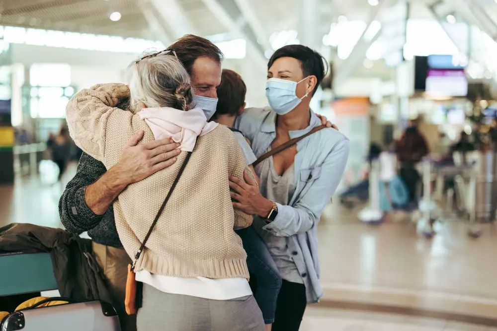 Elderly person greeting family at airport